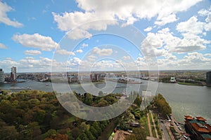 Wide angle overview at 100 metres height over the Rotterdam Skyline with blue sky and white rain clouds