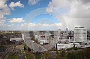 Wide angle overview at 100 metres height over the Rotterdam Skyline with blue sky and white rain clouds