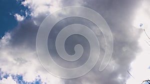 A wide-angle panorama of a blue sky with slowly moving white clouds.