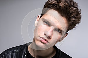 Wide angle portrait Young male model in black clothes posing in studio white background. Guy wearing black classic leather jacket