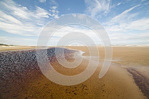 Wide angle rain water lake at the beach with blue sky