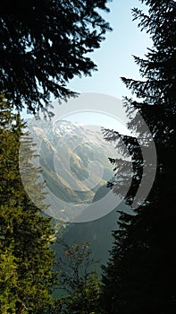 Wide-angle scenic landscape of a mountain peak with a lake below. photo