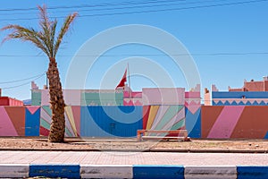 Wide angle shot colorful buildings and palm tree in the town of Tagonite in Draa Valley, Morocco