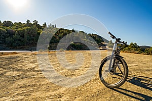 Wide angle shot of an electric bicycle parked on a dirt against highway in Greece, Europe