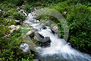 A wide angle shot of a river flowing through the forest with mountain surrounding in India. Dehradun city of uttarakhand