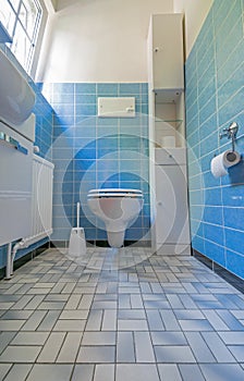 A wide angle shot of a toilet with the seat down