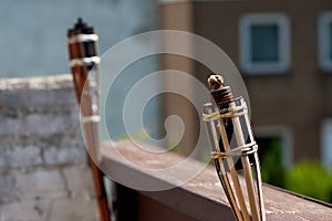 Wide angle shot of two unlit tiki torches next to each other on a building