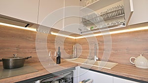 Wide angle tilt shot of modern white and wooden beige kitchen interior