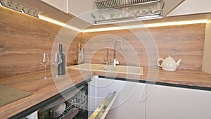 Wide angle tilt shot of modern white and wooden beige kitchen interior