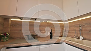 Wide angle tilt shot of modern white and wooden beige kitchen interior