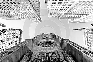 Wide angle upward view of Trinity Church at Broadway and Wall Street with surrounding skyscrapers, Lower Manhattan, New