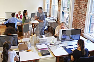 Wide Angle View Of Busy Design Office With Workers At Desks