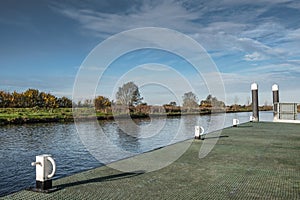 Wide angle view of a canal boat mooring platform seen within a wide expanse of water.