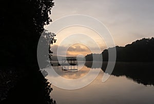 Wide angle view of a dock and reflection in the water on Lake Lanier in Georgia, USA at sunrise with clouds in the sky photo