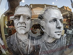 Wide angle view of faces of souvenir statuettes in store window
