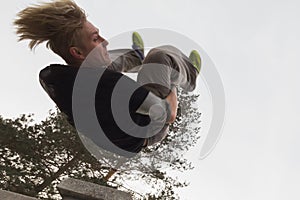 Wide angle view - flip parkour jumping in winter snow park - free-run training photo