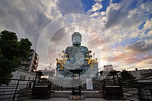 Wide angle view of  the Great Buddha,Hyogo Daibutsu at  Nofukuji Temple with sky,clouds and light evening sun, Kobe ,Japan