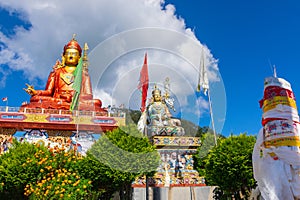 Wide angle view of Holy statue of Guru Padmasambhava or born from a lotus, Guru Rinpoche, Blue sky and white clouds, Samdruptse,