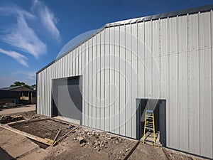 Wide angle view of the outside of a warehouse on a backdrop of blue sky.