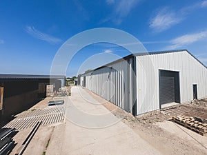 Wide angle view of the outside of a warehouse on a backdrop of blue sky.