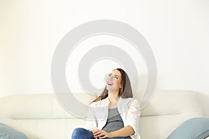 Woman sitting on couch and looking above photo