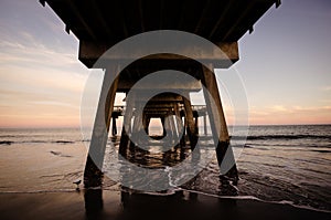 Wide angle view of the Tybee Island Pier in Georgia. Colorful sunset with pinks and purple colors in the sky