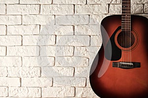 Wide banner with acoustic guitar with a white bricks background