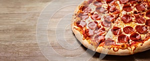 Wide banner of a handmade pepperoni pizza on a rustic wooden table, copy space, ai