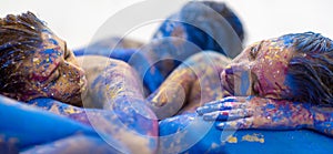 wide banner panorama portrait of three sexy young women with dots of white, blue, yellow, purple color paint. Decorative, creative