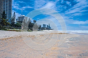 Wide beach with tide going out and city stretching to horizon - Gold Coast Australia