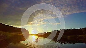 Wide beautiful river at sunset, tourists paddling boat. Slowmo