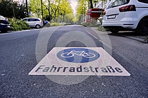 Wide bike road in an avenue with parked cars