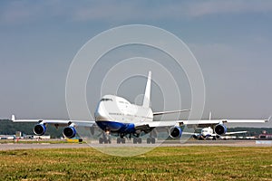 Wide body airplane taxiing on the main taxiway and then another plane