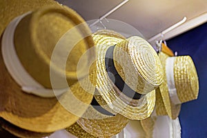wide-brimmed straw hats hanging on hangers in stores. Summer is coming