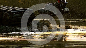 A wide bucket of the excavator digs up the soil from the bottom of the river at sunset. Cleaning and deepening of the