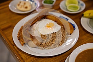 wide capture of bandeja paisa with chicharron, potato, ground beef, rice, fried egg, and a plantain at latin restaurant