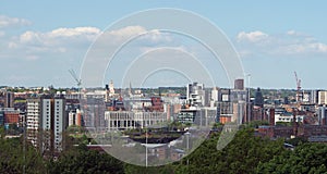 a wide cityscape view of leeds city centre taken from above showing office and apartment buildings the city hall and university