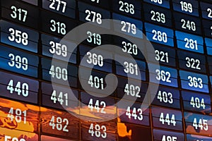 Wide curved futuristic multiple panel video presentation wall with sequence of numbers on many screens.Streaming media