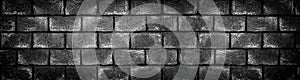 Wide dark concrete brick wall. Black shabby texture. Panoramic gloomy grunge background