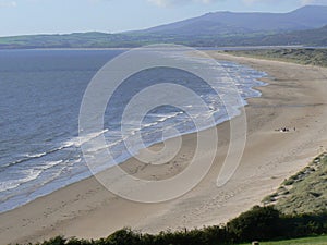 Wide deserted coastal beach with low tide and sand dunes