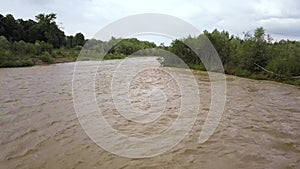 Wide dirty river in flooding period during heavy rains in spring.