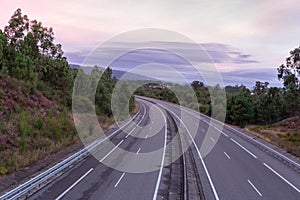 Wide empty highway with curve in the morning. Travel and destination background. Free asphalt road with mountain background.