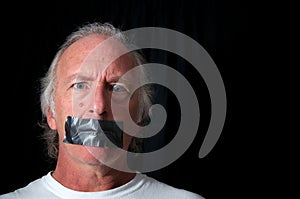 Wide eyed man with duct taped mouth photo