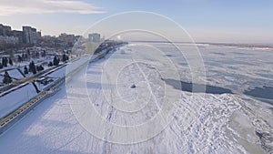 Wide frozen Volga river in winter day and public transport hovercraft, aerial