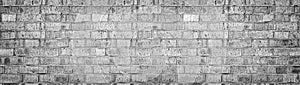 Wide gray brick wall texture. Rough light brickwork. Old cracked blocks panorama. Retro grunge widescreen background