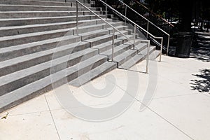 Wide gray concrete stairs in an outdoor urban street landscape, metal railing, creative copy space