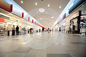 Wide hall and buyers in trading centre with shops