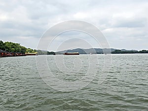 Wide lake with boats and hills under a cloudy sky photo