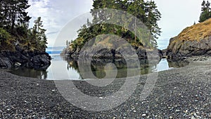 A wide lengthened view of a beautiful bay with a rocky beach and beautiful island, This is the east sooke coast trail photo