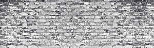 Wide light gray shabby brick wall texture. Old masonry with peeling white paint. Weathered brickwork panoramic background